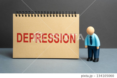 Tired businessman stands near a notebook with the word Depression. Symbolizing mental health issues, stress, burnout, and emotional exhaustion at work. Tired businessman stands near a notebook with the word Depression. Symbolizing mental health issues, stress, burnout, and emotional exhaustion at work. 134105060