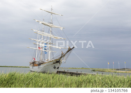 Sailing ship docked at Marker Wadden harbour in the Netherlands on a cloudy day with flags fluttering in the wind 134105766