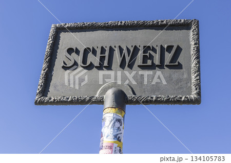 Border sign between Austria and Switzerland during hike to Schesaplana in Ratikon mountain range 134105783