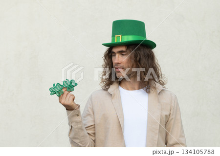 Man in green traditional hat choice shamrock clover glasses for St Patricks day celebration. Man in green traditional hat choice shamrock clover glasses for St Patricks day celebration. 134105788