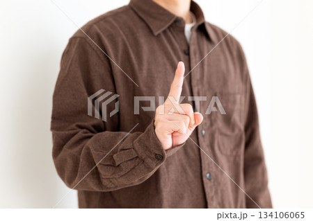 人差し指を立てるカジュアル姿のミドル男性 134106065