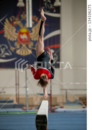 Junior girl perform on balance beam Junior girl perform on balance beam 134106275