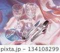 Elegant crystal glassware and cutlery on pastel silk background 134108299