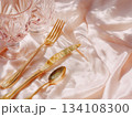 Minimal pastel table setting with golden cutlery and crystal glasses 134108300