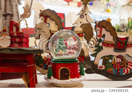 A glass ball with a Santa Claus and Christmas tree figurine inside A glass ball with a Santa Claus and Christmas tree figurine inside 134109191