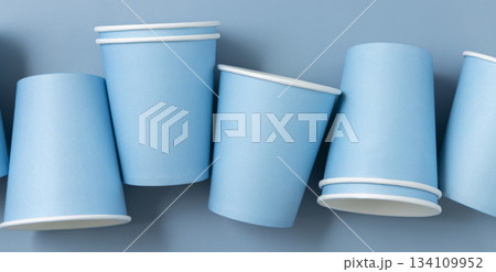 Disposable light blue paper cups in a line topview, mockup. Single-use no plastic containers Disposable light blue paper cups in a line topview, mockup. Single-use no plastic containers 134109952