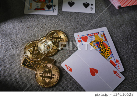Playing cards and bitcoin cryptocurrency tokens on table 134110528