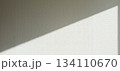 窓から斜めに日光が差し込む部屋の白い壁 134110670