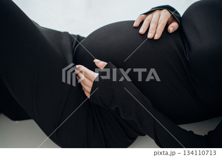 Expecting mother relaxing at home in black outfit 134110713