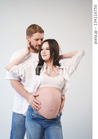 Couple embraces during maternity photo session at home Couple embraces during maternity photo session at home 134110750