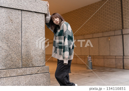 壁にもたれている女性 134110851