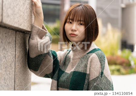 壁にもたれている女性 134110854