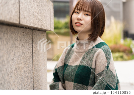 壁にもたれている女性 134110856