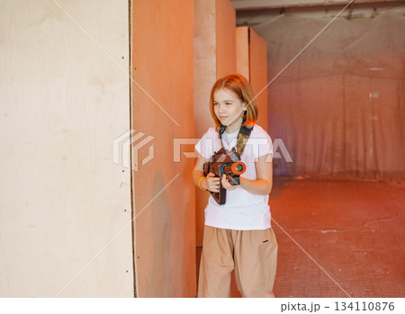 Young girl plays in an indoor laser tag arena 134110876