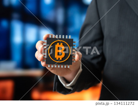 A Bitcoin microchip in the hands of a businessman. The cryptocurrency mining industry. Blockchain infrastructure and digital asset technology. Crypto market, fintech and mining hardware 134111272