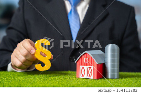 An official holds a paragraph near a farm. New laws and regulations on agriculture. Policy reforms and rural sector oversight. Legislative updates, agro-industry and compliance issues in farming. 134111282