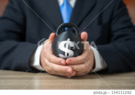 A heavy burden of debt in the hands of a businessman. Rising interest costs create risks. Weight of obligations slows development. Heavy burden of debt in the hands of a businessman. 134111292