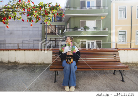 Woman enjoys peaceful moment in bustling city environment during midday Woman enjoys peaceful moment in bustling city environment during midday 134113219