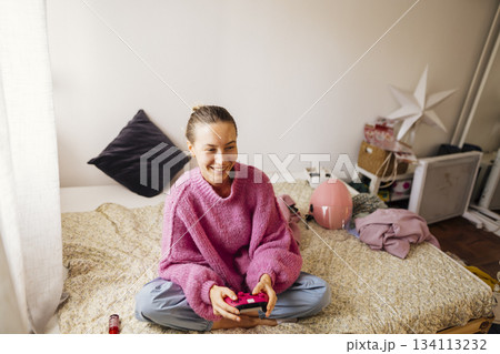 Cheerful youngster enjoying her playtime amid plush companions 134113232