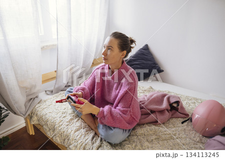 Calm woman intently concentrated on game controller in bedroom 134113245