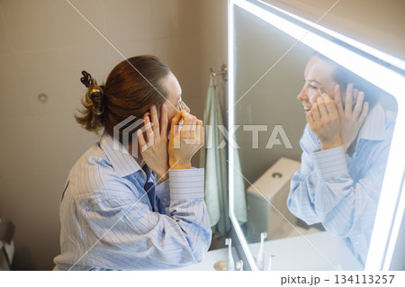 caucasian woman gently rubbing cream, beauty blogger moment caucasian woman gently rubbing cream, beauty blogger moment 134113257