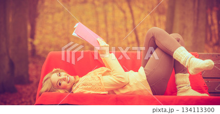 Blonde girl with book in autumn park 134113300