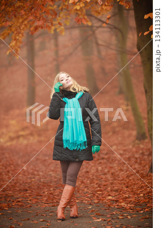 Attractive woman in autumnal park. 134113301