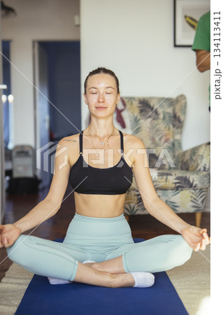 relaxed woman engaging in silent meditation surrounded by calming light and cozy environment 134113411