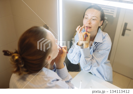 Calm mom completes makeup routine amid busy household tasks 134113412