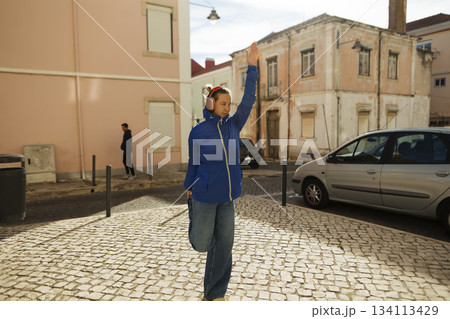 Individual in vibrant clothing requests transportation on city street 134113429