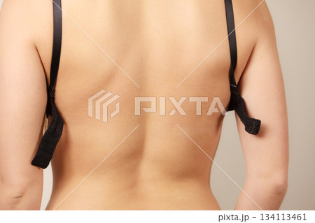 Woman putting on black bra lingerie back view 134113461