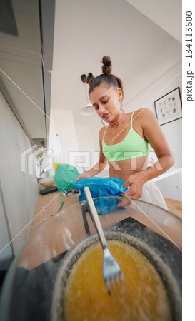 A Candid Cooking Moment in a Modern, Stylish Kitchen Filled with Culinary Creativity and Passion 134113600