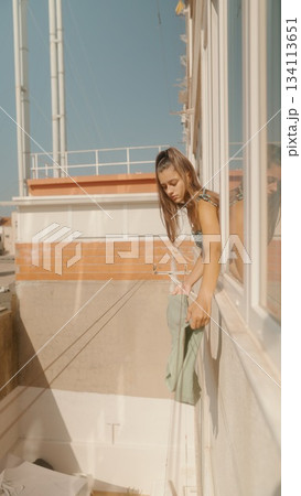 A Young Woman Gracefully Posing by a Beautiful Window on a Bright Sunny Day, Radiating Joy 134113651