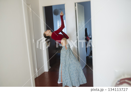 Expressive dancer performing in confined space with dynamic lighting 134113727