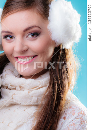 Happy woman in white earmuffs on blue 134113799