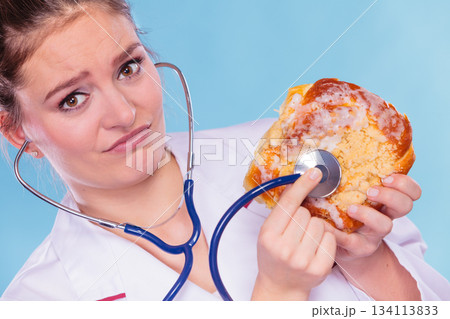 Dietitian examine sweet roll bun with stethoscope. Dietitian examine sweet roll bun with stethoscope. 134113833