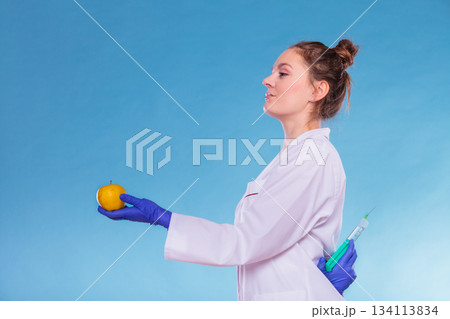 Scientist doctor with apple and syringe. GM Food. Scientist doctor with apple and syringe. GM Food. 134113834