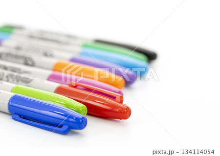 Close-up view of a set of colorful markers with caps on a clean white background showing various vibrant colors in a diagonal 134114054