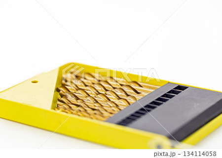 Set of gold metal drill bits arranged neatly in a bright yellow plastic case with a black organizer section on a white background Set of gold metal drill bits arranged neatly in a bright yellow plastic case with a black organizer section on a white background 134114058