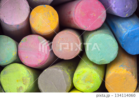 Close-up of stacked colorful chalk sticks showing various bright hues with textured surfaces in a tightly packed arrangement Close-up of stacked colorful chalk sticks showing various bright hues with textured surfaces in a tightly packed arrangement 134114060