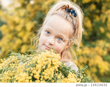 Smiling Girl Holding Mimosa Outdoors 134114232