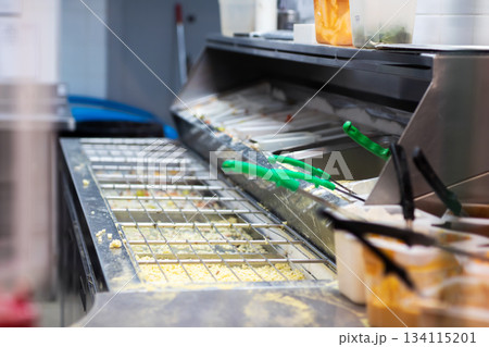 Food station setup, Hygienic fastcasual food preparation area with condiments and utensils Food station setup, Hygienic fastcasual food preparation area with condiments and utensils 134115201