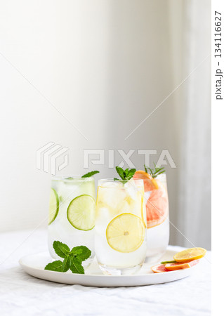 Glasses with cold lime and lemon lemonade with mint garnish. 134116627
