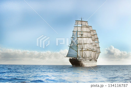 Large sailing ship navigating calm ocean under cloudy sky 134116787