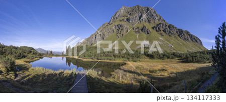 Scenic view of Lake Wiegensee in Gaschurn, Montafon, Vorarlberg, Austria during daytime with clear skies and greenery 134117333