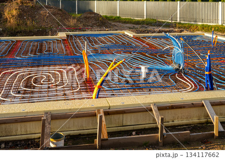 Underfloor heating pipes arranged on reinforced foundation grid before concrete pouring 134117662