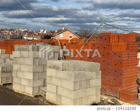 Stacks of red bricks and concrete blocks at construction supply yard. Building materials, industry, development, housing infrastructure and city growth. 134118295