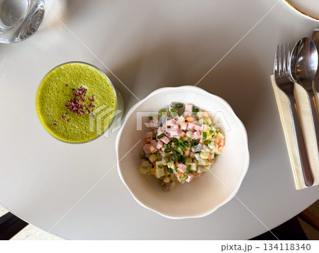 Matcha latte and Olivier salad top view. Friendly lunch setup, cozy atmosphere and slow mindful eating Matcha latte and Olivier salad top view. Friendly lunch setup, cozy atmosphere and slow mindful eating 134118340