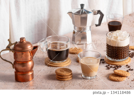 Coffee assortment with espresso cups, iced drink and moka pot on beige table 134118486