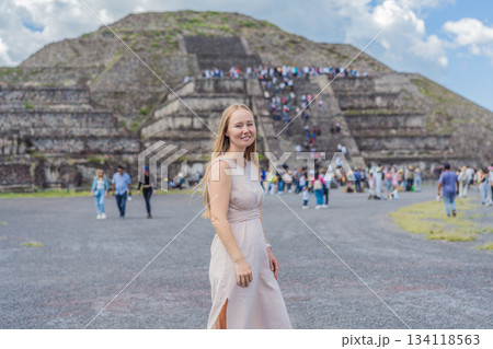 Female tourist standing in front of Teotihuacan pyramids in Mexico, enjoying sightseeing, adventure, and cultural heritage. Travel, tourism, and exploration concept 134118563